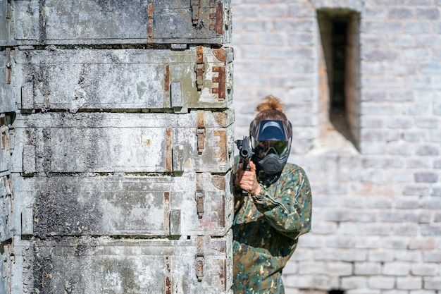 Giovane donna in azione mentre gioca a paintball