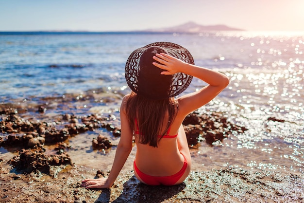 Giovane donna in bikini che si rilassa sulla spiaggia in Mar Rosso Concetto di viaggio e vacanza estiva