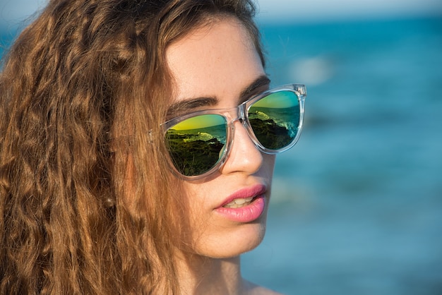 Giovane donna in bikini sulla spiaggia assolata