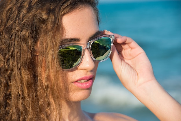 Giovane donna in bikini sulla spiaggia assolata