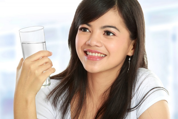 Giovane donna in buona salute che tiene un bicchiere d'acqua e sorridere