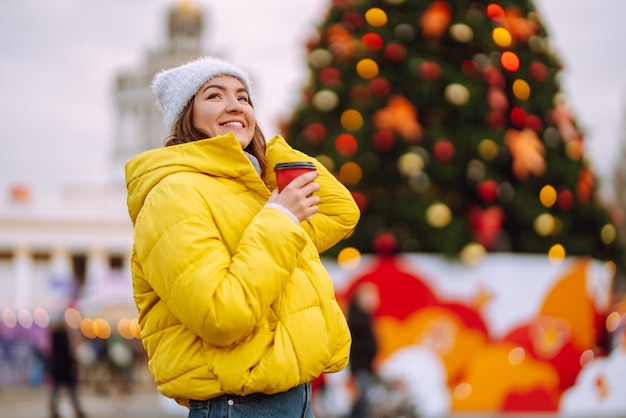 Giovane donna in caldo abbigliamento invernale in posa al festival Vacanze invernali