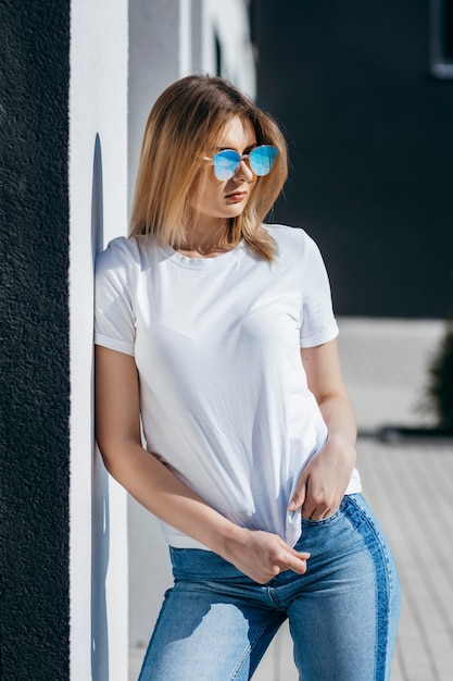 Giovane donna in camicia e jeans in posa all'aperto