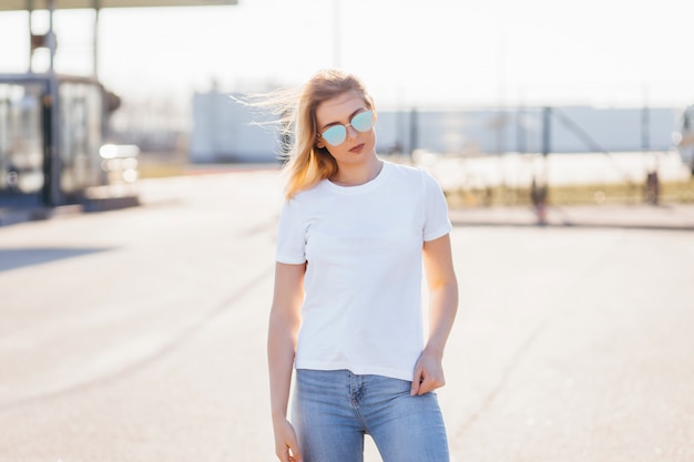 Giovane donna in camicia e jeans in posa all'aperto