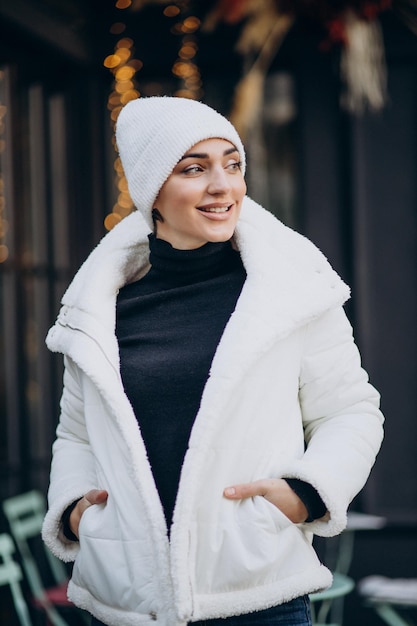 Giovane donna in cappello invernale in piedi all'aperto