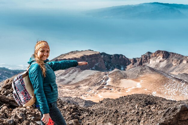 Giovane donna in cima al vulcano El Teide a Tenerife o montagna che guarda giù per la valle con splendida vista del vulcano Pico Viejo