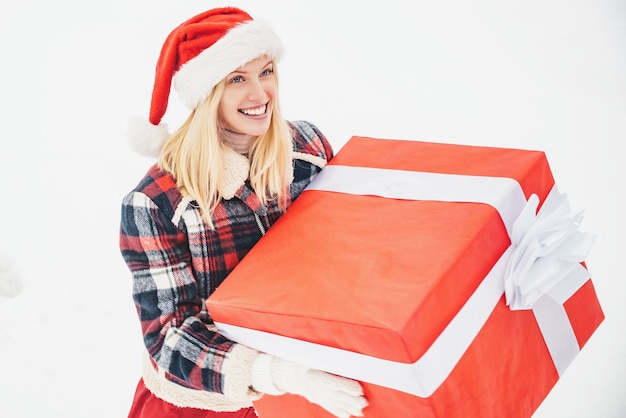 giovane donna in costume da Babbo Natale in possesso di un grande regalo