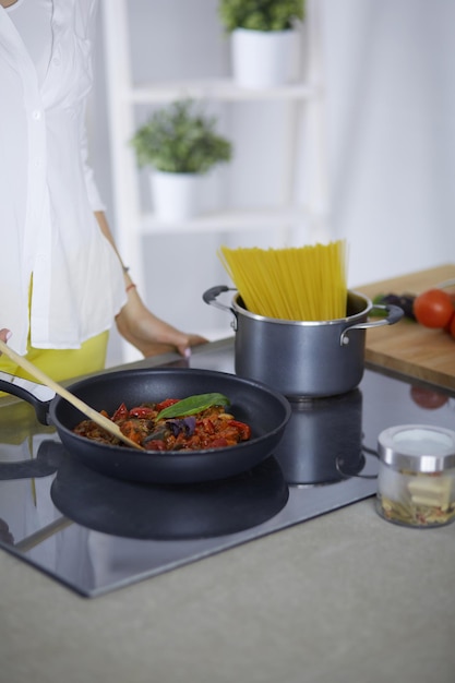 Giovane donna in cucina a preparare un cibo