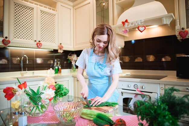 Giovane donna in cucina a preparare un'insalata