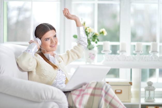 Giovane donna in cuffie che ascolta musica tu