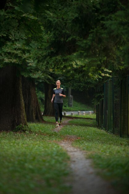 Giovane donna in esecuzione nella foresta boscosa Area - Formazione ed esercizio per Trail Run Marathon Endurance - Fitness stile di vita sano Concept