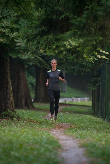 Giovane donna in esecuzione nella foresta boscosa Area - Formazione ed esercizio per Trail Run Marathon Endurance - Fitness stile di vita sano Concept