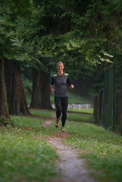 Giovane donna in esecuzione nella foresta boscosa Area - Formazione ed esercizio per Trail Run Marathon Endurance - Fitness stile di vita sano Concept