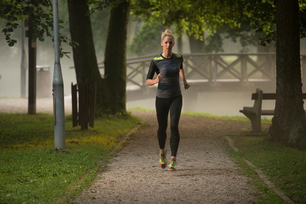 Giovane donna in esecuzione nella foresta boscosa Area - Formazione ed esercizio per Trail Run Marathon Endurance - Fitness stile di vita sano Concept