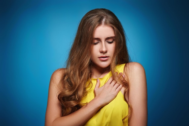 Giovane donna in maglietta gialla su sfondo blu