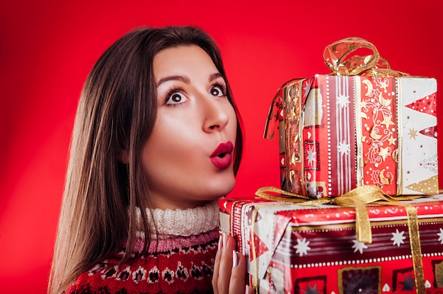 giovane donna in maglione islandese con scatole regalo. Concetto di celebrazione di Natale.