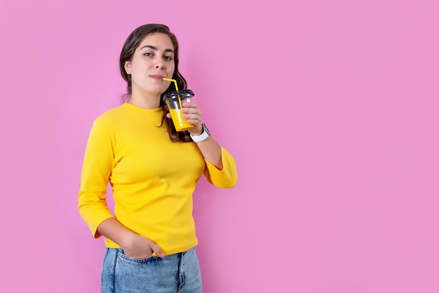 Giovane donna in piedi e bere succo