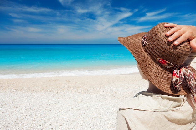 Giovane donna in piedi sulla spiaggia e in cerca di un mare