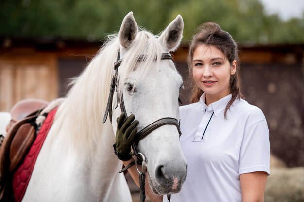 Giovane donna in polo bianca e guanti in pelle nera