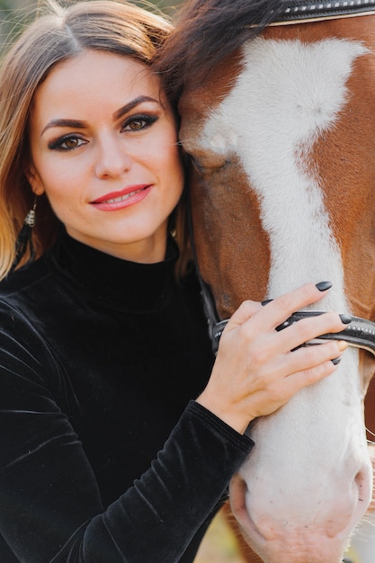 Giovane donna in posa con un cavallo