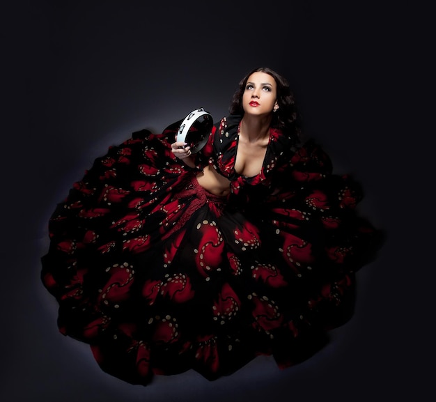 Giovane donna in posa in costume da flamenco isolato