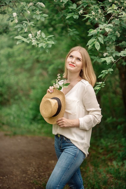 Giovane donna in posa nella foresta di primavera