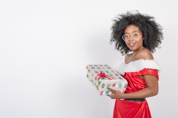 Giovane donna in possesso di un regalo vestito con un costume di natale