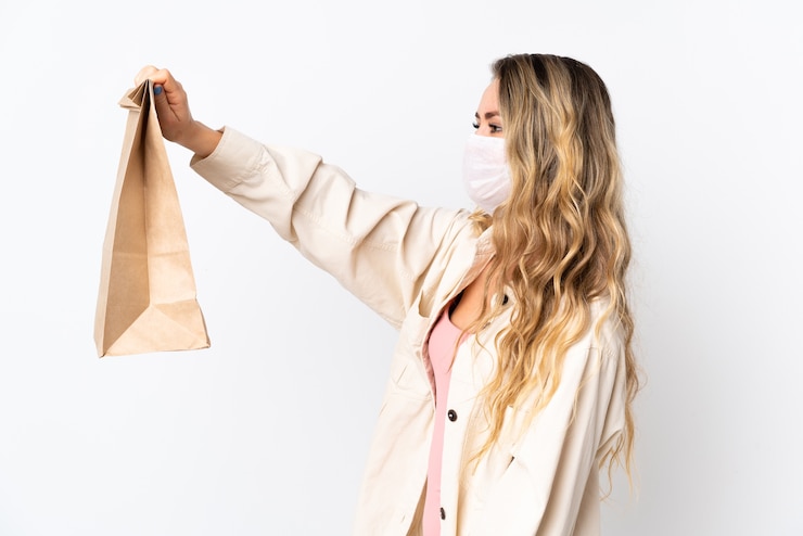 Foto giovane donna in possesso di un sacchetto della spesa isolato