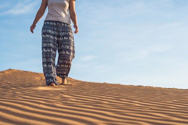 Giovane donna in rad deserto sabbioso al tramonto o all'alba