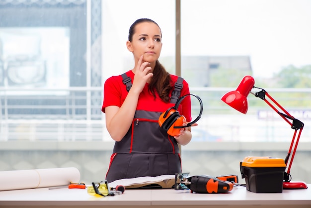 Giovane donna in tute facendo riparazioni