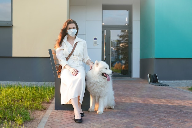 Giovane donna in un abito bianco con il suo cane
