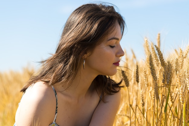 Giovane donna in un campo di grano al tramonto