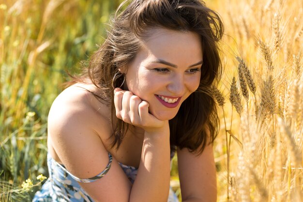 Giovane donna in un campo di grano al tramonto