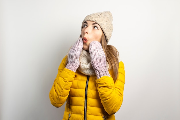 Giovane donna in un cappello e guanti berretti isolati