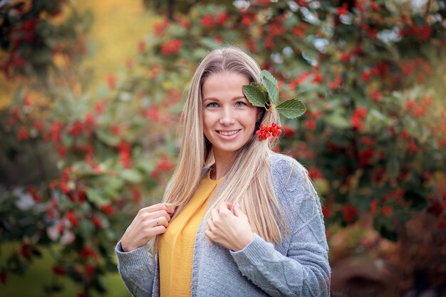 Giovane donna in un cardigan grigio nella sosta di autunno