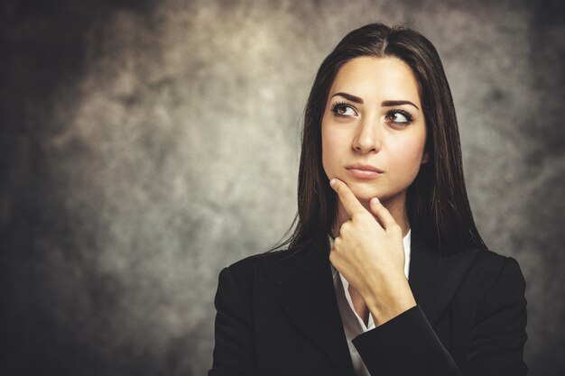 Giovane donna in un'espressione pensierosa su una parete grungy