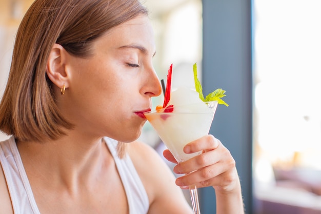 giovane donna in un resort con cocktail