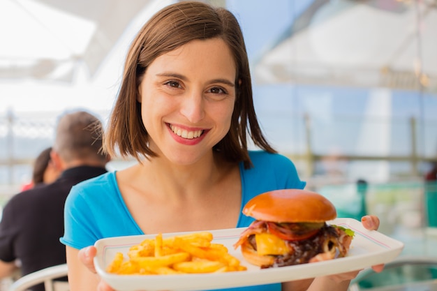 giovane donna in un ristorante con un hamburger