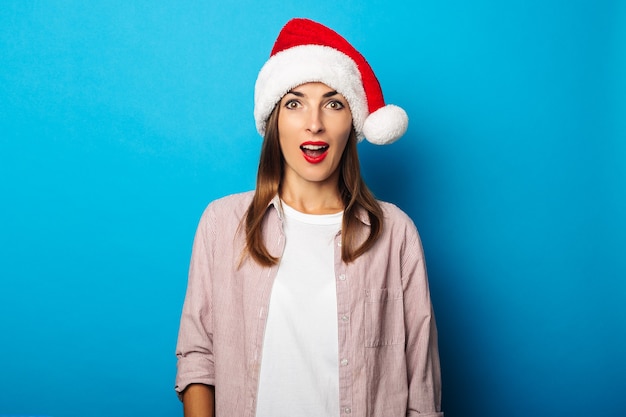 Giovane donna in una camicia che indossa un cappello di Babbo Natale