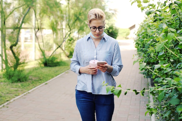 Giovane donna in una camicia che tiene una tazza di caffè