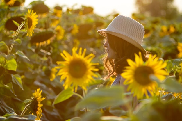 Giovane donna in una fattoria di girasoli
