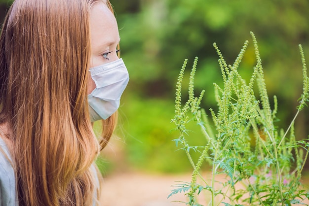 Giovane donna in una maschera medica a causa di un'allergia all'ambrosia