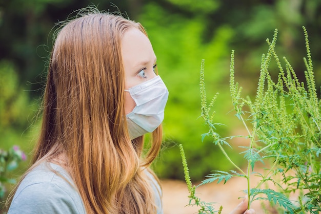 Giovane donna in una maschera medica a causa di un'allergia all'ambrosia