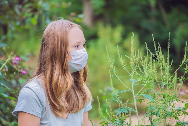 Giovane donna in una maschera medica a causa di un'allergia all'ambrosia