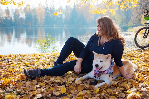 Giovane donna in una passeggiata con il suo cane Akita inu di razza