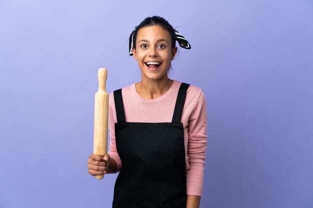 Giovane donna in uniforme da chef con espressione facciale a sorpresa