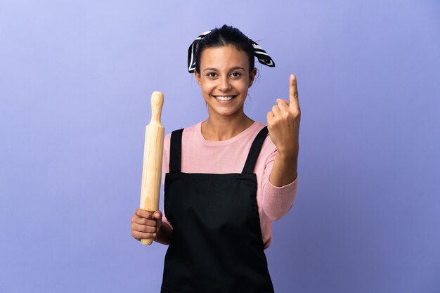 Giovane donna in uniforme del cuoco unico che fa gesto venente