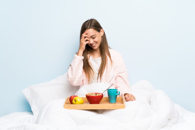 Giovane donna in vestaglia con risata colazione