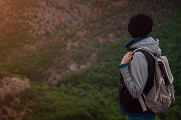 Giovane donna in viaggio sulla cima della scogliera della montagna