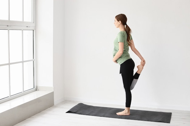 Giovane donna incinta che pratica yoga in palestra